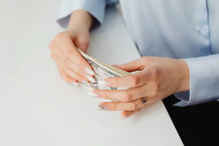 Close-up of hands holding US dollar bills showcasing minimum wage